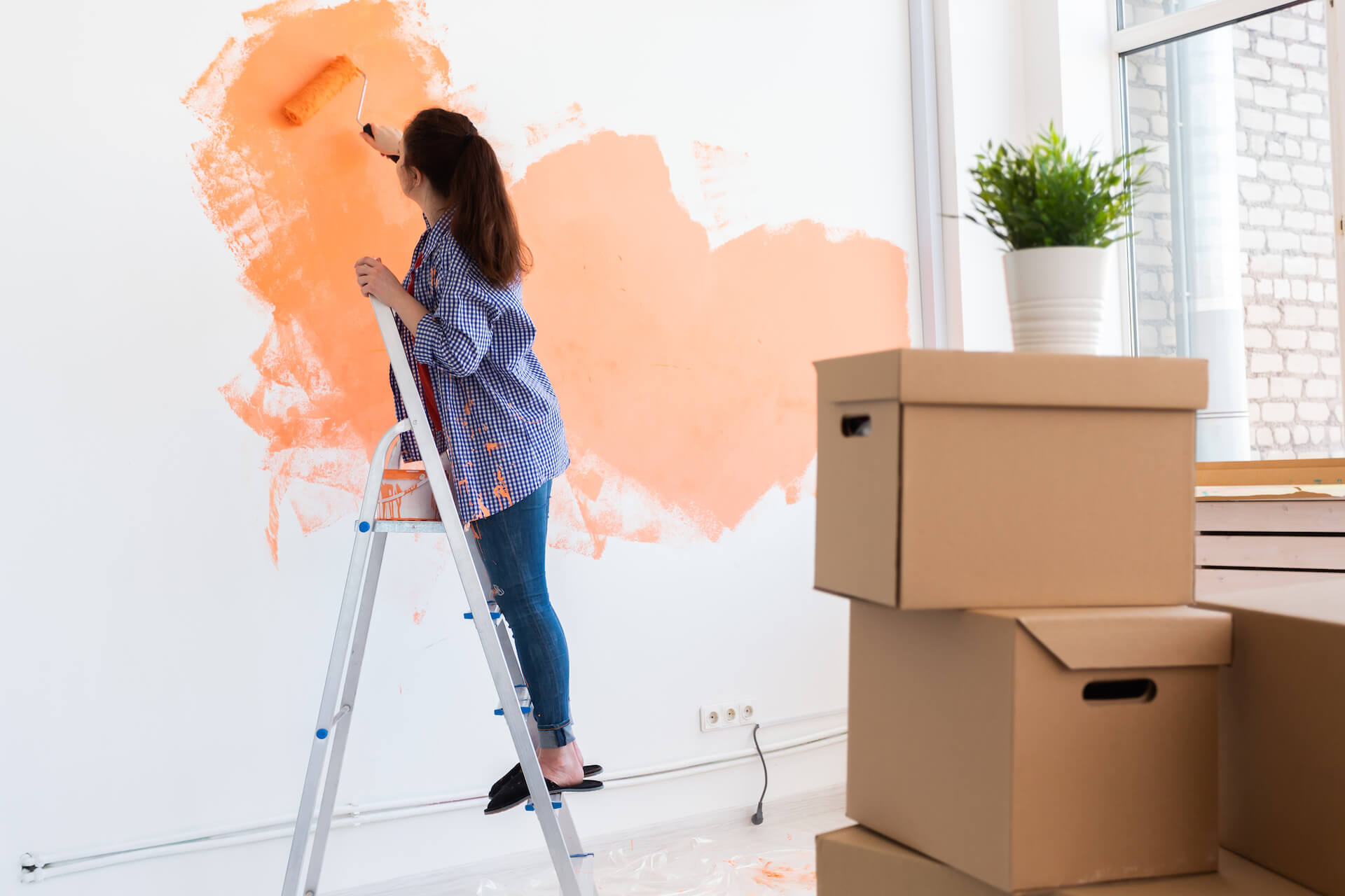 cheerful-woman-painting-the-walls-of-new-home-ren-2021-12-09-07-27-07-utc.jpg